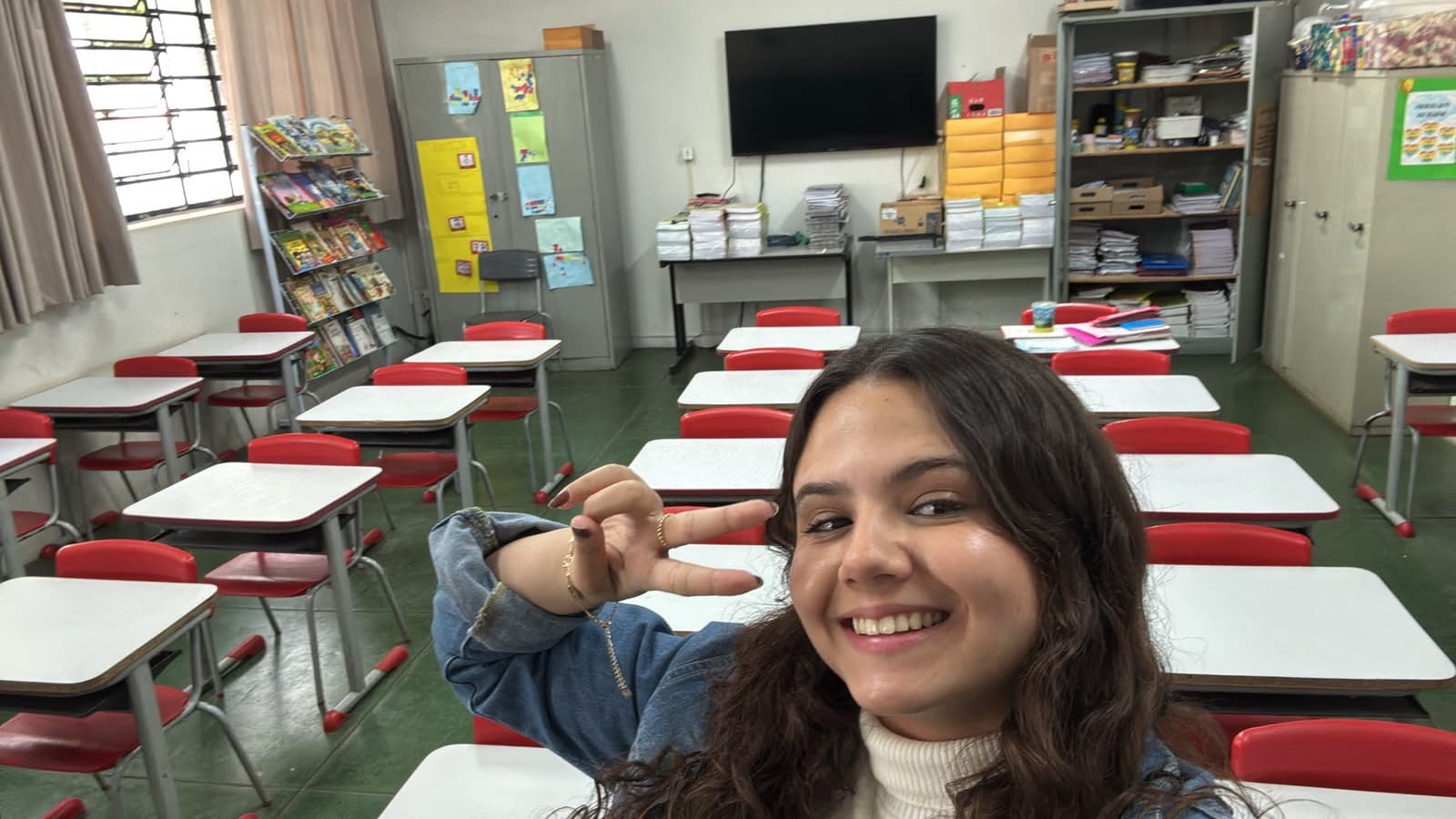 Prof. Isa Rios sorrindo na sua sala de aula